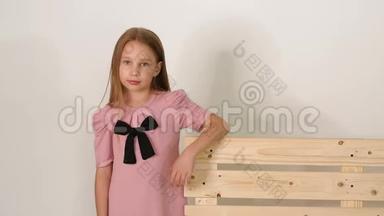 白色背景的工作室里靠近长凳的<strong>可爱</strong>小女孩的肖像。