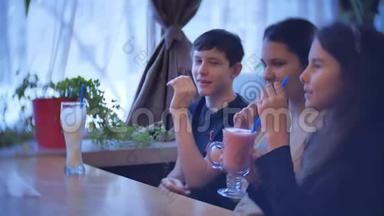 一群孩子在咖啡馆里喝奶昔。 青少年室内儿童咖啡馆儿童慢视频乐趣欢乐