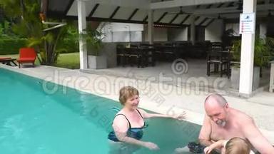 祖父母在游泳池里和孙女玩耍