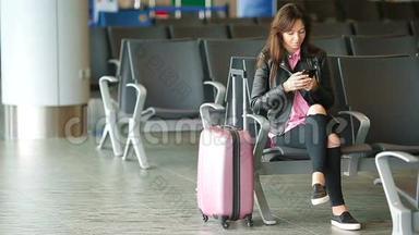 航空公司乘客在机场休息室等待航班飞机。 在候<strong>诊室</strong>找时间的白人女人