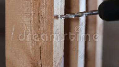 专业的老<strong>木工用</strong>钻头在抛光的木板上打洞。