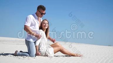 可爱的夫妇坐在沙漠里的沙滩上