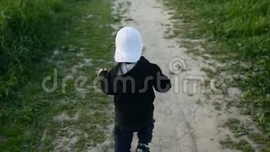 一个穿着带帽子的夹克的孩子在田野里奔跑