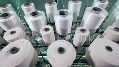 缝纫卷筒在一<strong>家纺</strong>织厂用白色的线旋转。