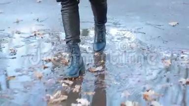 穿着黑色战靴的女孩在<strong>雨后</strong>的水坑里飞溅