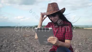 智慧生态是一种收获农业的耕作理念。 女孩农民的生活方式与数字平板电脑研究地球污垢中