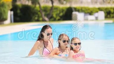 妈妈和两个孩子在豪华游泳池里享受暑假