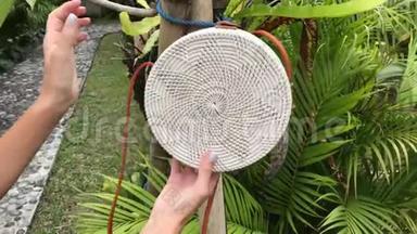 女人的手与Stylich环保藤袋在热带背景。 巴厘岛。