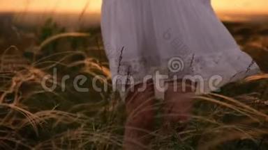 <strong>美丽</strong>的女孩穿着白色的裙子，在<strong>夕阳</strong>下穿过<strong>美丽</strong>的田野。 年轻女子在草地上慢跑