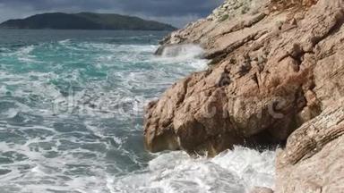 纯净的蓝色水域海洋，海岸波浪打破和飞溅冒险海上海岸冲浪岩石。 录像。 夏季