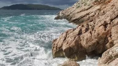 纯净的蓝色水域海洋，海岸波浪打破和飞溅冒险海上海岸冲浪岩石。 录像。 夏季