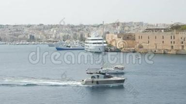 船，游艇在马耳他瓦莱塔市的背景下航行.. 宽镜头，背景中新建房屋..