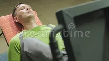 一个超重的男人在健身房里用模拟机做腿部按压。健身训练。健康生活方式理念