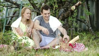 年轻夫妇在野餐时喝酒聊天