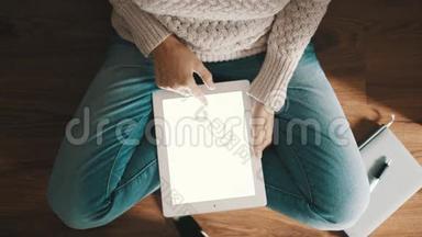 坐在地板上用平板电脑的女人