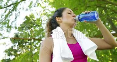 在公园锻炼后，女人擦了擦眉头和喝水