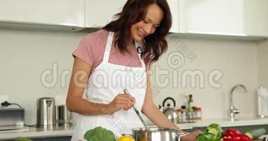 女人在柜台上翻着炖锅，里面有很多蔬菜