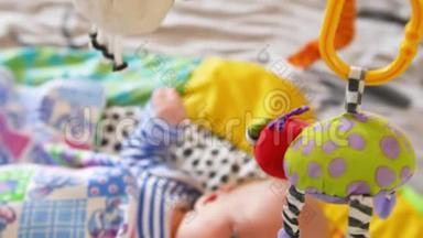 顶部的照片，可爱的婴儿与另一个躺在婴儿床和看旋转的小熊玩具