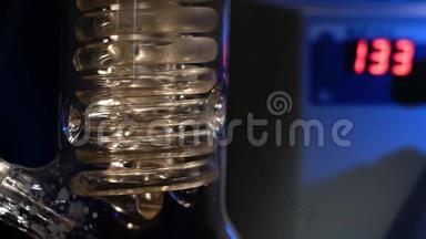 水晶螺旋。 螺旋玻璃管与水关闭。 玻璃螺旋管从回流冷凝器与自来水