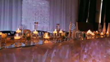 婚宴大厅内部细节与<strong>装饰</strong>餐桌设置在餐厅。 蜡烛和白色<strong>花瓣装饰</strong>