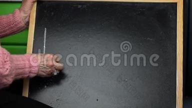 老妇人在黑板上写字