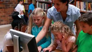 <strong>学生们</strong>和老师一起看图书馆里的<strong>电脑</strong>