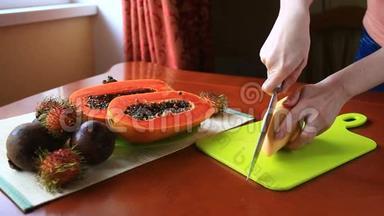 餐桌上的异国热带水果。 泰国水果。 木瓜水果切成两半.. 特写