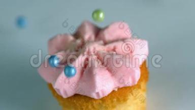 糖球落在蛋糕上，上面有粉红色的糖霜