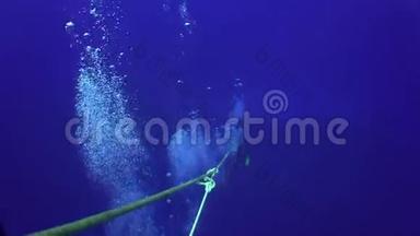 潜水员沿着绳索潜入深海海底。