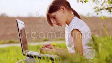 带着笔记本电脑在公园里的白人男孩。 有笔记本电脑的<strong>孩子</strong>。 带手提电脑的<strong>乡下</strong>少年。