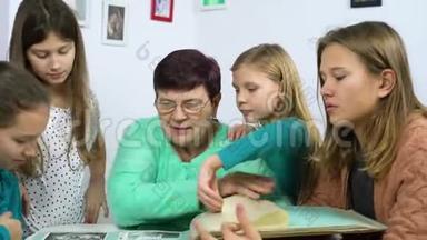 祖母和四个孙女在家看旧相册