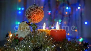 新年和圣诞装饰品。 燃烧蜡烛。 闪耀的加兰。 背景模糊。 漂亮的红球..