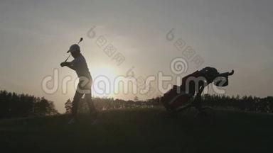 日落时带高尔夫球袋的男孩高尔夫球手剪影