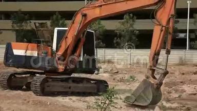 库存视频录像1920x1080挖掘机在一个建筑工地相当于土地清理一个建筑工地，挖掘机铲斗工作。
