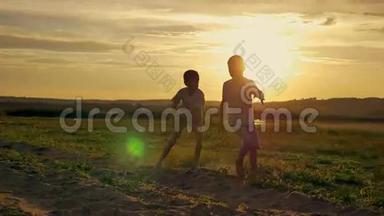 两个快乐的孩子在公园里跑来跑去。 在田野上，两兄弟正在日落时分玩耍
