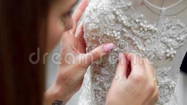 贴身时装设计师为新娘在他的工作室针花边婚纱。 女裁缝创造了<strong>独一无二</strong>的