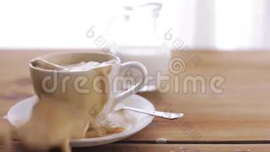 咖啡和糖落在桌子上的杯子上