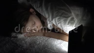 <strong>儿童</strong>在黑暗中玩平板电脑，女孩在<strong>床</strong>上浏览互联网，而不是睡觉