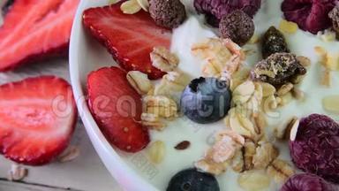 由酸奶、蓝莓、覆盆子、蓝莓、梅斯利制成的典型正宗早餐组成。 概念