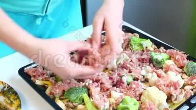 那个女人正在把肉末放在烤盘上。 上面已经放了切碎的蘑菇、土豆和花椰菜。