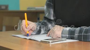 不知名的学生用钢笔在笔记本上写<strong>课文</strong>