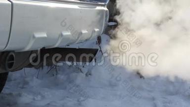 消声器运转车产生的废气.. 在冬季道路上行驶的汽车的轮子。
