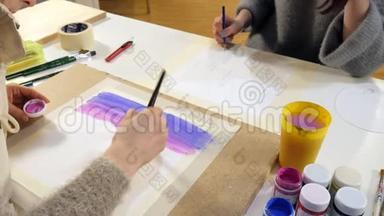 两名成年女子在艺术学校附近用彩色丙烯酸颜料作画