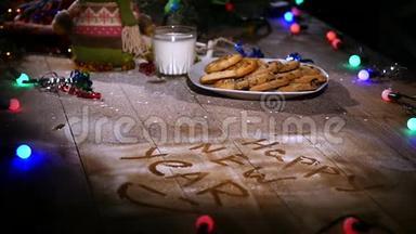 木制棕色桌子，上面装饰着圣诞用品和花环。 圣诞节时一杯牛奶和一盘饼干