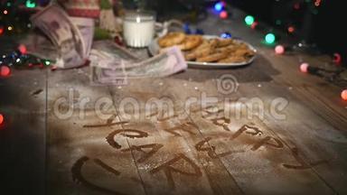 木制棕色桌子，上面装饰着圣诞用品和花环。 圣诞节时一杯牛奶和一盘饼干