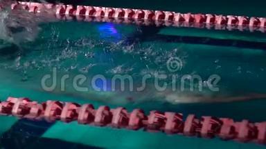 男游泳运动员从起点跳下来，开始在游泳池里游泳。 职业运动员训练：潜水和溅水
