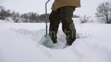 渔夫，在白雪覆盖的湖面上钻了一个洞，寻找一个好的钓鱼地点。