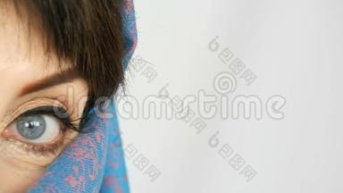 一位阿拉伯中年成年妇女的肖像，她有着不寻常的美丽的蓝色大眼睛，传统的睫毛很长