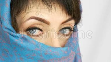 一位阿拉伯中年成年妇女的肖像，她有着不寻常的美丽的<strong>蓝色大眼睛</strong>，传统的睫毛很长