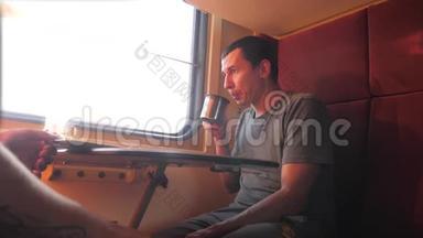 男人坐在<strong>火车车厢</strong>里，手里拿着铁路，喝着咖啡和茶。 慢动作视频。 两个人喝酒